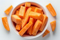 Fresh cut carrot sticks in white ceramic bowl on white background. Raw orange vegetable pieces arranged for healthy snacking and meal preparation.