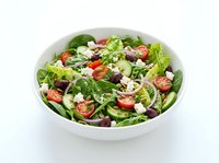 Fresh garden salad with tomatoes, lettuce, feta cheese and red onions in white bowl on white background. Healthy eating.