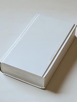 Minimalist white hardcover book on light background with soft shadow, blank cover ready for design mockup. Clean contemporary style for publishing projects.