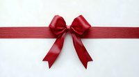 Red satin ribbon bow on white background for gift wrapping, holiday decorations and festive occasions. Isolated element ready for design projects.