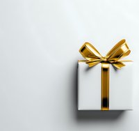 White gift box with golden ribbon bow on light background for holiday celebrations and special occasions.