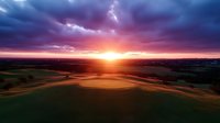 Dramatic sunset over rolling agricultural fields with vibrant purple and pink clouds, golden hour lighting illuminating farmland landscape from aerial perspective.