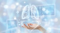 Human hands presenting glowing lung anatomy hologram with digital particles on soft blue medical background for healthcare technology concepts.
