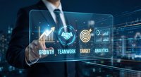 Professional businessman touching futuristic holographic interface with business analytics icons showing growth charts and teamwork symbols for corporate success.