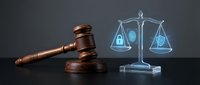Wooden gavel and holographic digital scales of justice on dark background representing legal technology, law enforcement, and modern judicial system.