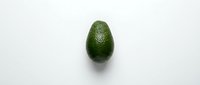 Fresh green avocado with textured skin isolated on white background, ready for food and nutrition design projects, healthy eating concepts, and culinary marketing materials.