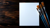 Blank white canvas with blue wooden paintbrushes on dark rustic wooden background, artistic workspace setup for painting and creative projects.