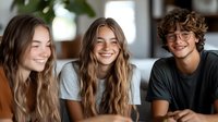 Young diverse friends laughing together indoors. Casual lifestyle portrait of multicultural group showing genuine joy and connection during relaxed social gathering.