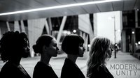 Modern diverse group of four people standing together in profile against urban architectural background, representing teamwork, collaboration, and contemporary community in black and white.