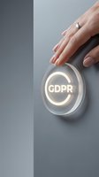 Woman's hand pressing a glowing GDPR button on a gray wall, symbolizing data privacy compliance, regulation, and digital security concepts.