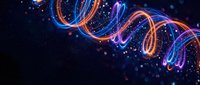Glowing neon light trails creating dynamic swirls and curves against dark starry background. Futuristic energy waves with vibrant colors for digital art projects.