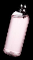 Clear plastic bottle filled with pink liquid, tilted at an angle, isolated on transparent background. Ready for beauty, skincare, and cosmetic design projects, stickers, and print on demand.