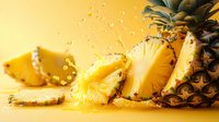 Fresh pineapple slices with juice splash and water drops on yellow background, bright tropical fruit composition for healthy food design.