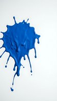 Vibrant cobalt paint splash with dynamic dripping effect on white background, suitable for creative design, art projects, and abstract visual content.