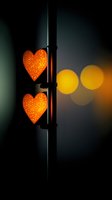 Glowing orange heart-shaped lights against dark background with bokeh effects create romantic atmosphere for Valentine's Day or love-themed designs.