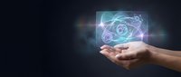 Hand holding glowing atomic structure hologram with electrons orbiting nucleus on dark background representing science technology and innovation concepts.