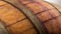 Wooden barrel with metal hoops showing rich grain texture and rustic craftsmanship for brewing, winery, distillery, and traditional storage applications.