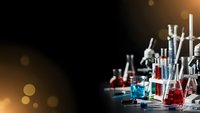Laboratory glassware with colorful chemical solutions on dark background with warm bokeh lights for scientific research and experimentation.