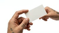 Hands exchanging blank white business card on isolated background for corporate identity and professional networking design mockup.
