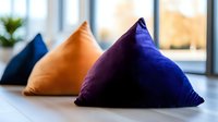 Colorful velvet triangle cushions in orange and purple arranged on modern floor for contemporary home decor and interior design relaxation space.