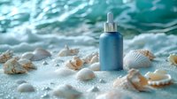 Blue cosmetic dropper bottle on sandy beach with seashells and ocean waves, natural skincare concept for beauty and wellness products in spa setting.