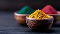 Vibrant curry powder and colorful spices in wooden bowls on dark background, selective focus on yellow turmeric powder. Food photography for culinary concepts.