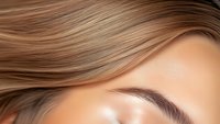 Close up view of young Caucasian woman with light brown hair showing perfectly shaped eyebrow and natural makeup look. Professional beauty and cosmetics concept.