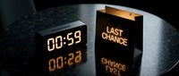 Digital countdown clock showing 00:59 next to a glowing last chance shopping bag on dark reflective table, urgency and limited time sale concept.
