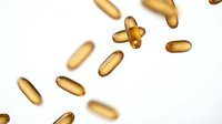 Golden omega-3 fish oil capsules floating on white background. Dietary supplements for health and wellness nutrition isolated for design use.