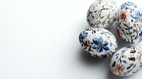 White Easter eggs decorated with delicate blue and brown floral pattern on light background, traditional holiday design elements for spring celebration.