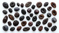 Assorted cocoa beans isolated on white background, displaying various sizes, shapes, and roasted tones from dark brown to black, suitable for food, agriculture, and culinary design projects.