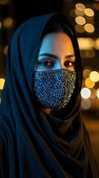 Young Middle Eastern woman wearing ornate sequined face mask and blue hijab with warm bokeh lights background for fashion and cultural diversity concepts.