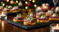 Elegant beef canapes with herbs on slate board create festive holiday appetizer spread with warm bokeh lights and candles for Christmas entertaining.