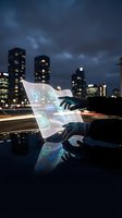 Hands holding transparent digital tablet with glowing holographic interface displaying data analytics and technology icons against urban cityscape at dusk with illuminated skyscrapers.
