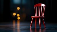 Red wooden chair on dark background with soft bokeh lights creating moody atmospheric composition, minimalist furniture photography for interior design.