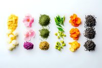 Colorful food ingredients in rows including edible flowers, spices, herbs and noodles arranged on white background for creative cooking and garnishing.