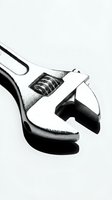 Adjustable wrench held in hand against white background, isolated tool for construction, maintenance, repair work, and DIY projects.