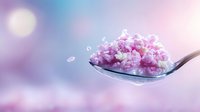 Pink cottage cheese on metal spoon against blurred purple and blue bokeh background, fresh dairy product macro photography for healthy eating concept.