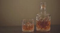 Crystal decanter and glass with amber whiskey on dark background, luxury spirits photography showcasing premium beverage and elegant barware.