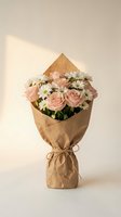 Fresh flower bouquet with pink roses and white daisies wrapped in brown kraft paper against neutral background for gifting and special occasions.