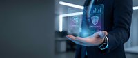 Businessman holding digital holographic interface with security icons, data analytics charts, and shield symbol for cybersecurity and business protection concepts.