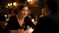 Elegant mature woman enjoying wine during romantic dinner date in upscale restaurant with warm ambient lighting and intimate atmosphere.