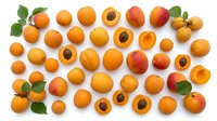 Fresh ripe apricots with green leaves arranged on white background. Whole and halved organic stone fruits showing pits. Summer harvest produce.