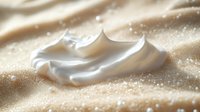 Whipped cream dollop on sandy surface with sparkles, suitable for bakery, dessert, and food styling projects.