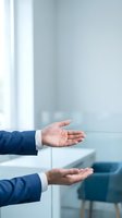 Businessman hands in protective gesture showing care and security in modern office environment for insurance and safety concepts.