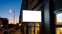Urban blank billboard mockup on brick building wall at twilight for advertising display and marketing campaigns in modern city street environment.