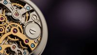 Luxury mechanical watch movement with exposed gears and intricate clockwork mechanism on dark background for precision timepiece concepts.