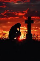Silhouette of grieving person kneeling beside cross at cemetery during dramatic sunset with red orange sky clouds for memorial remembrance grief loss concepts.