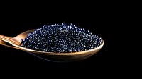 Fresh black caviar on golden spoon against dark background, luxury gourmet food close-up with selective focus and dramatic lighting.