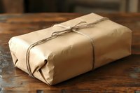 Rustic parcel wrapped in brown kraft paper with twine bow on vintage wooden table, perfect for delivery and shipping concepts.